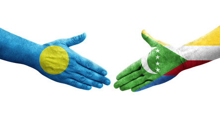 Handshake between Comoros and Palau flags painted on hands, isolated transparent image.