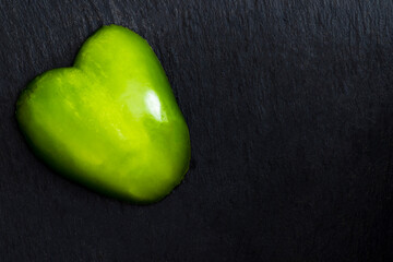Heart-shaped pepper piece on a black slate plate