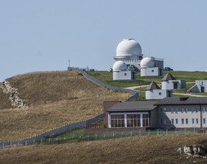 Astronomical observatory in the Caucasus mountains with a territory for research on a mountain hill, on a warm October day in autumn