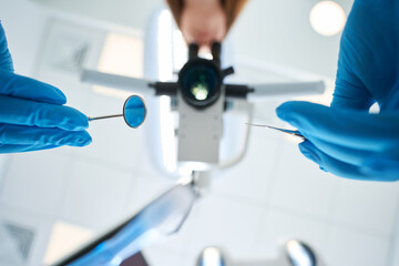 Stomatologist using diagnostic equipment during primary patient examination