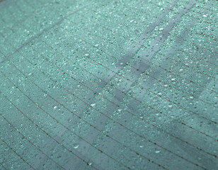 Close up of rain drops on the rear windshield of a car.