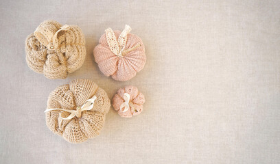 Hobby background with handmade knit pumpkins. DIY, craft decoration for fall and winter holidays. Flat lay, top view