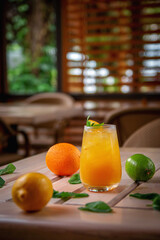 Alcoholic refreshing cocktail with orange, passion fruit and ice cubes, on the summer terrace of the restaurant