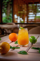 Alcoholic refreshing cocktail with orange, passion fruit and ice cubes, on the summer terrace of...