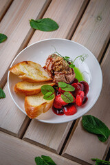 Chicken liver pate with croutons and strawberries in sweet sauce