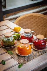 An assortment of teas in glass teapots, on the summer terrace of the restaurant. Ginger, sea buckthorn and fruit tea