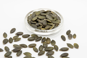 Close up of green and white squash seeds on a white background