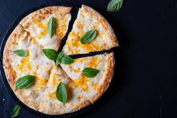 Italian pizza Margherita with cheese and basil on black concrete table top view