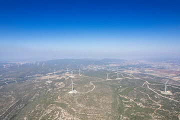 Obraz premium Aerial photo of a nice windmill on a green meadow with white clouds in the blue sky.