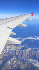 Obraz premium View from the airplane window. Alps, snow-capped mountains, clouds