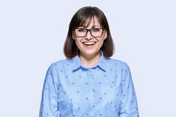 Middle aged smiling business woman over light background