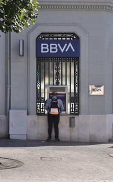 Caixa multibanco numas instala&ccedil;&otilde;es de banco espanhol com uma pessoa do sexo masculino a utilizar a caixa para movimentar e consultar a conta banc&aacute;ria