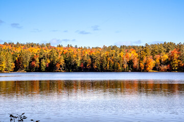 Londonderry, VT - USA - Oct. 8, 2022 Landscape autumnal view of the picturesque 102-acre Lowell Lake, located in Vermont’s Lowell Lake State Park. Red, yellow orange trees reflecting in the water.