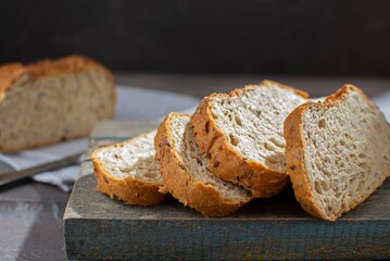 Slices of white bread on a wooden table. The concept of a food crisis due to problems with the supply of grain, a decrease in bread consumption. Top view. Selective focus.