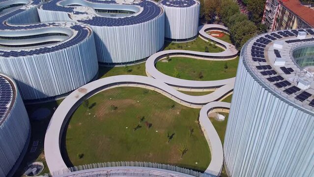 Aerial view of solar panels on the roof. The new campus of the SDA Bocconi School of Management is a modern building with classrooms. Autumn trees. Ecological energy. Milan Italy 11.2022