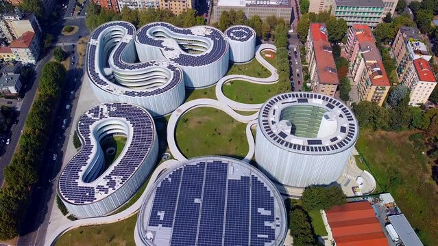 Aerial view of solar panels on the roof. The new campus of the SDA Bocconi School of Management is a modern building with classrooms. Autumn trees. Ecological energy. Milan Italy 11.2022