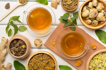 Herbal tea with ingredients on wooden background, top view