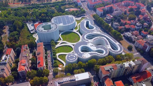 Aerial view of solar panels on the roof. The new campus of the SDA Bocconi School of Management is a modern building with classrooms. Autumn trees. Ecological energy. Milan Italy 11.2022