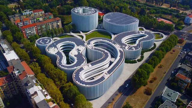 Aerial view of solar panels on the roof. The new campus of the SDA Bocconi School of Management is a modern building with classrooms. Autumn trees. Ecological energy. Milan Italy 11.2022