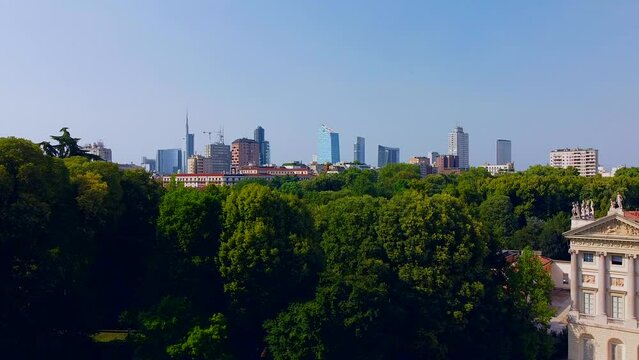 Aerial view of autumn trees in Giardini Indro Montanelli park and the skyline with new skyscrapers. View of modern business offices. Ecology. Clouds over the city. Green Planet. Milan. Italy, 