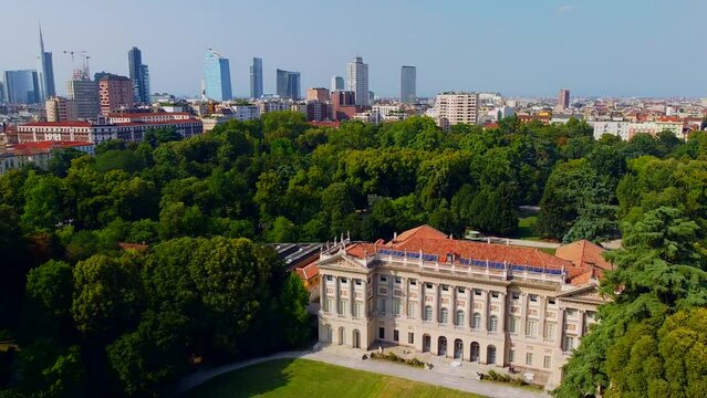 Aerial view of summer trees in Giardini Indro Montanelli park and skyline with new skyscrapers. View of modern business offices. Business. Tourism. Ecology. Clouds over the city. Green Planet. Milan. 