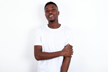 young handsome man wearing white T-shirt over white background laughing.