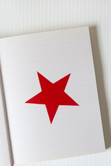 red vinyl star on notebook with lines