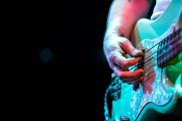 Band playing music and a gig in a venue, close up of a rock band playing guitars and instruments.