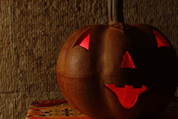 Calabaza de barro con los ojos boca y nariz iluminados en color rojo