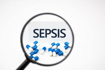 Text SEPSIS through a magnifying glass near the capsules. Diagnosis concept - SEPSIS.