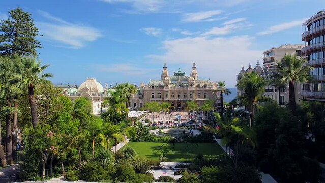 Aerial view of the old casino. area with palm trees. Luxurious super cars in front of the hotel. Monument and fountain. Modern architecture of the kingdom of MONTE CARLO, MONACO