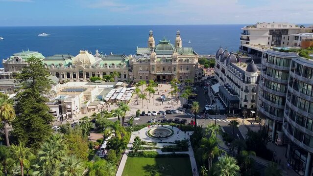 Aerial view of the old casino. area with palm trees. Luxurious super cars in front of the hotel. Monument and fountain. Modern architecture of the kingdom of MONTE CARLO, MONACO SEPTEMBER 2022