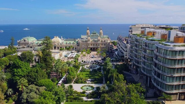 Aerial view of the old casino. area with palm trees. Luxurious super cars in front of the hotel. Monument and fountain. Modern architecture of the kingdom of MONTE CARLO, MONACO