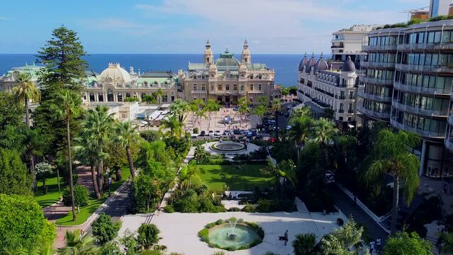 Aerial view of the old casino. area with palm trees. Luxurious super cars in front of the hotel. Monument and fountain. Modern architecture of the kingdom of MONTE CARLO, MONACO S