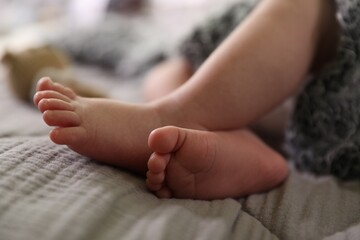 Adorable newborn baby with grey fluffy blanket in bed, closeup