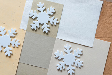 white foam snowflakes on neutral color paper 