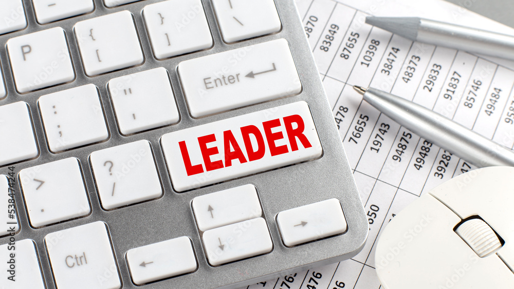 Poster leader text on a keyboard with chart and pencil