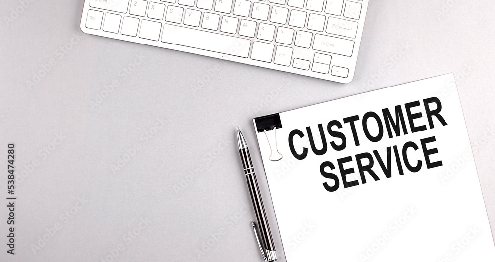 Aufkleber customer service text on paper with keyboard on grey background