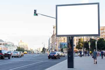 Blank horizontal large billboard in the city. Cars on the road, pedestrians on the sidewalk....