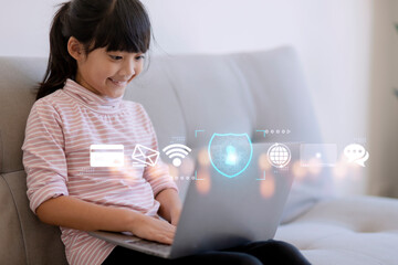 Child safety online. Little girl using laptop at home. icon of internet blocking app on foreground