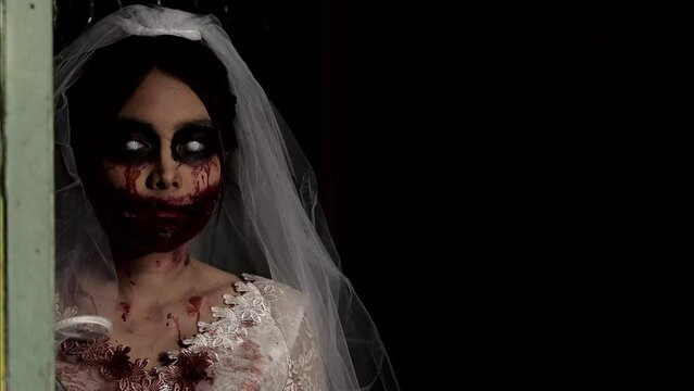 Portrait of asian woman make up ghost bride death and blood the horror is darkness scary horror scene for background,Halloween festival concept.