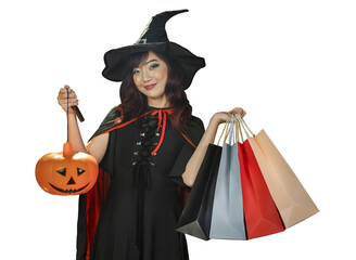 Asian girl in witch costume holding jack o lantern and shopping sale bag for halloween party trick or treat concept isolate on orange background