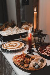 Halloween dishes on a table full of candlesticks and candles and other decorations, cookies, jelly...