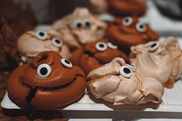 poop-shaped white and brown meringues with eyes
for halloween, funny sweets for halloween, close-up...
