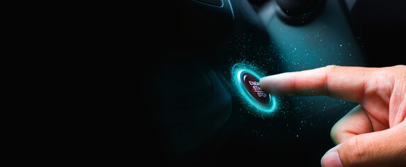 The driver palm as it presses the electric car engine start stop button with a blue light illuminated , panoramic banner with copy space on black background - obrazy, fototapety, plakaty
