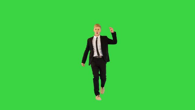 Witty guy in black office suit performs funny dance and sits on a twine in the end on a Green Screen, Chroma Key.