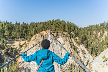 Woman crossing suspension bridge and conquering her fear