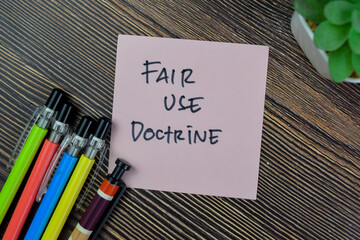 Concept of Fair Use Doctrine write on sticky notes isolated on Wooden Table.