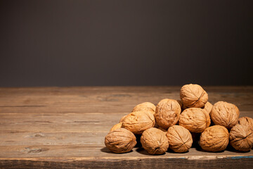 Nuts lie on an old wooden table on a dark background.