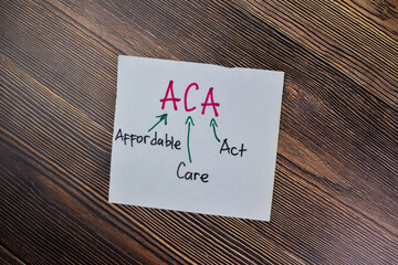 Concept of ACA - Affordable Care Act write on sticky notes isolated on Wooden Table.